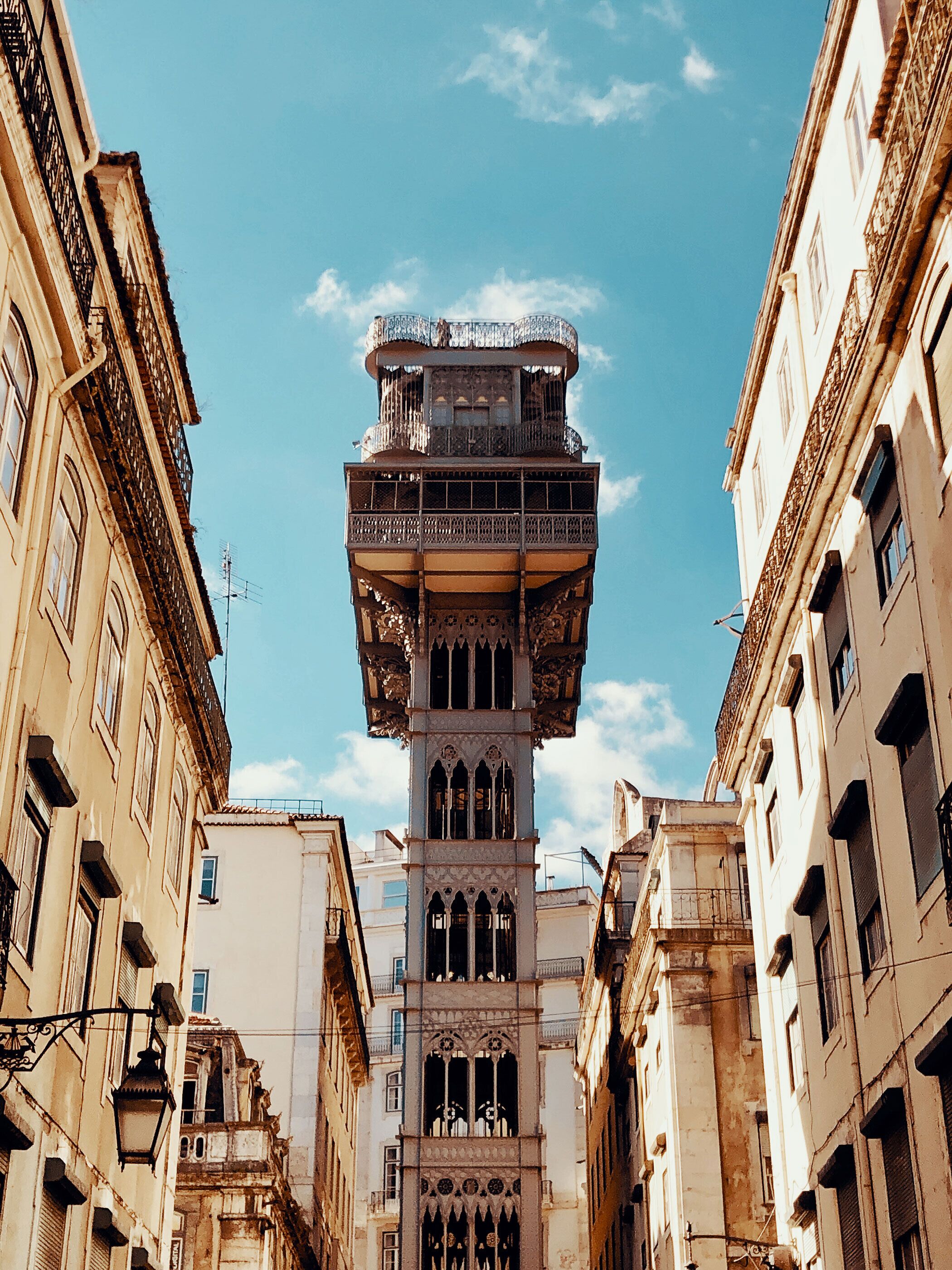 A historic building with a central tower featuring ornate balconies and a clock.