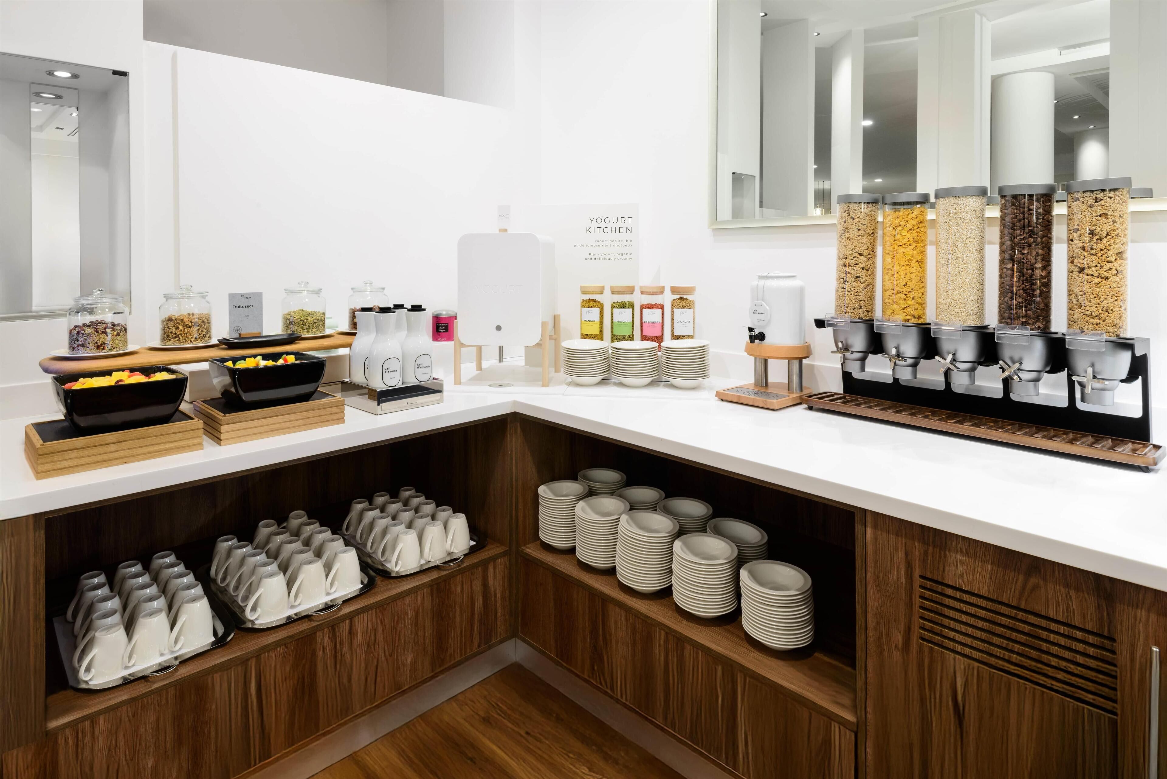 A breakfast buffet setup with various food items and drink dispensers.