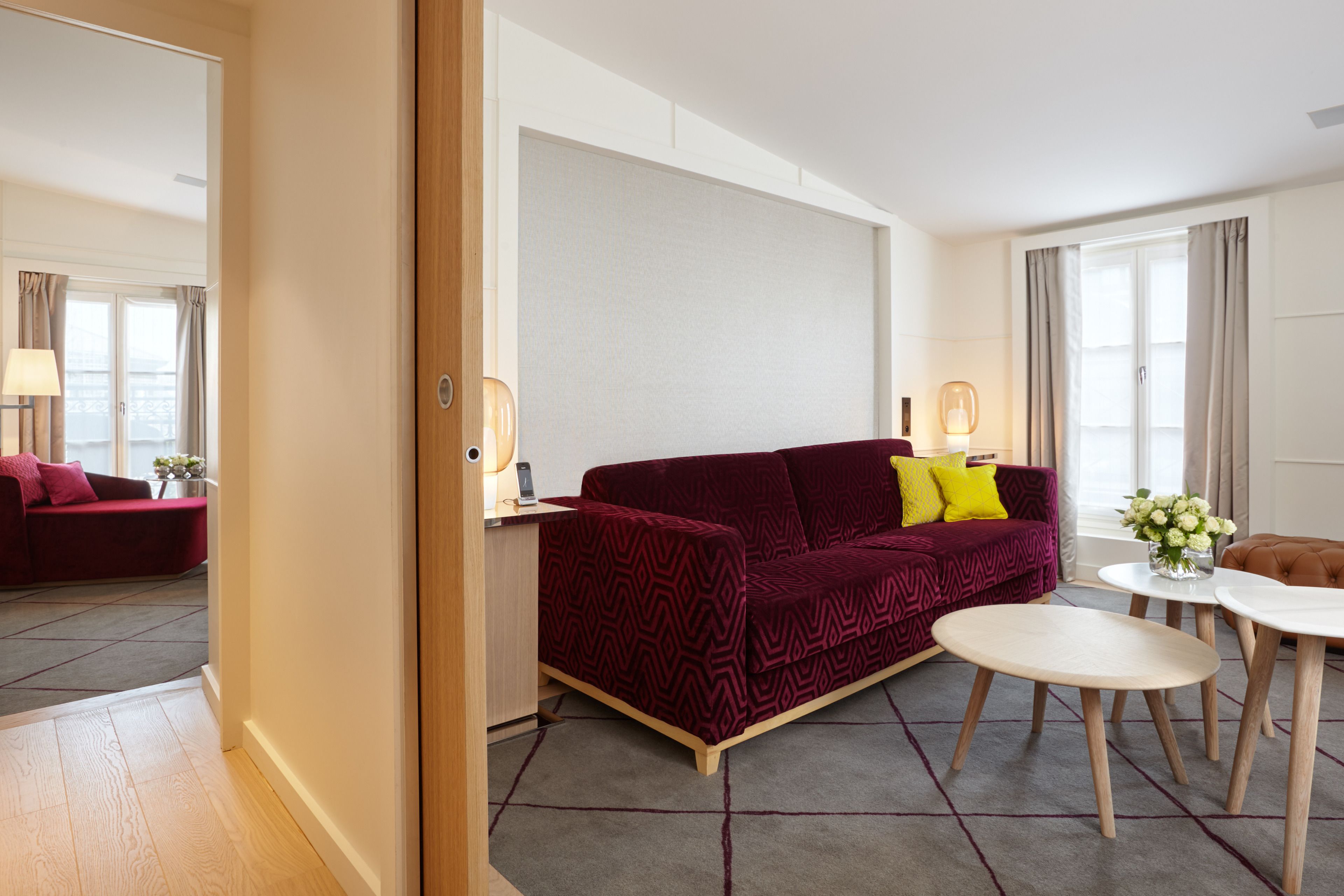 A modern living room with a patterned sofa, a round coffee table, and a small side table.