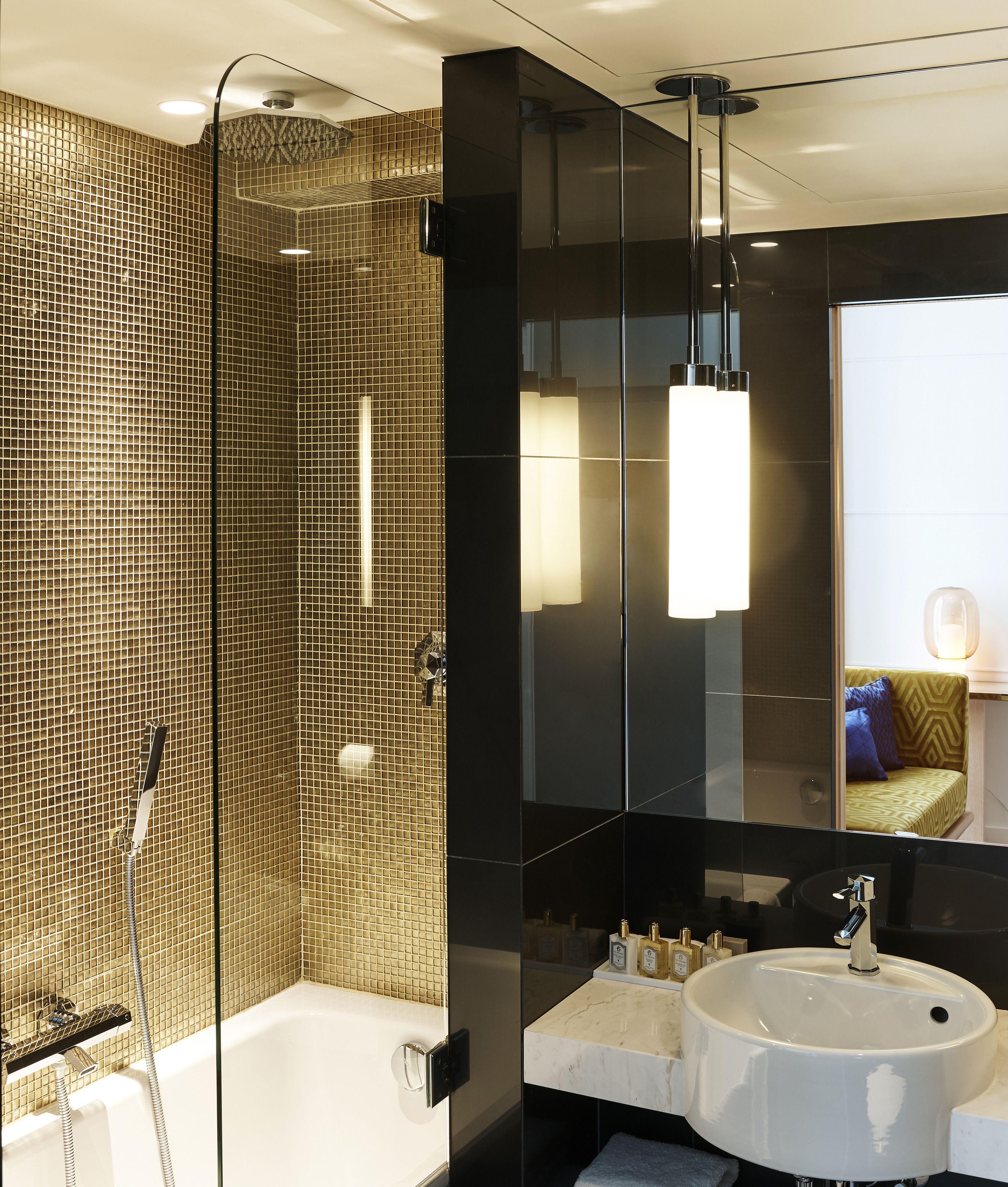A modern bathroom with a glass-enclosed shower, a white bathtub, and a vanity with a large mirror.