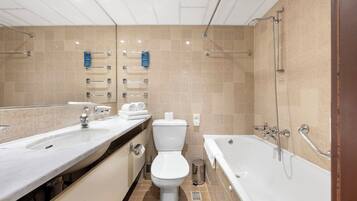 A modern bathroom with a large sink, toilet, and bathtub.