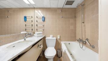 Une salle de bain moderne avec deux lavabos, des toilettes et une baignoire.