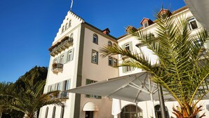 Un edificio de varios pisos con balcones, ventanas grandes y fachada blanca.