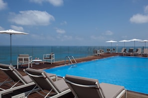 Piscine extérieure, parasols de plage, chaises longues