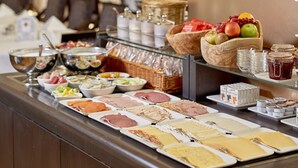 Un bufé con diversos alimentos y un centro de mesa floral.