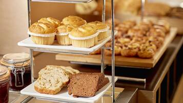 Een meerlaagse presentatie van gebakjes en muffins in een bakkerij.