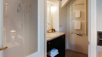 A modern bathroom with a vanity, a towel rack, and a heated towel rail.