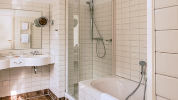 A modern bathroom with a glass-enclosed shower, a white sink with a mirror, and a bathtub.