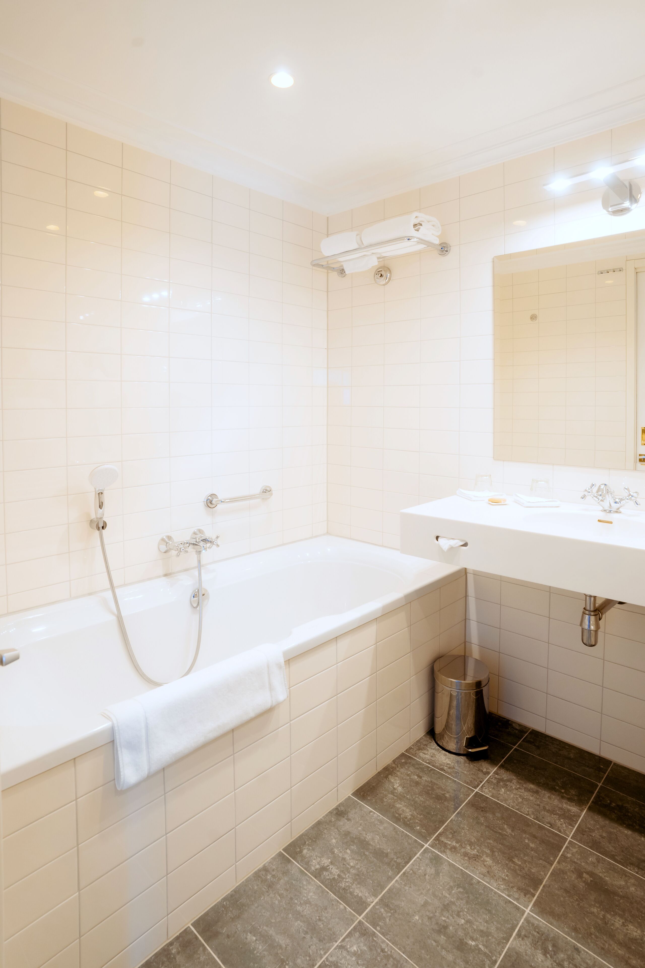 A modern bathroom with a bathtub, a sink, and a mirror.