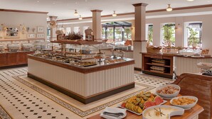 A buffet with various food items and a seating area with tables and chairs. - Sunday Resort Rügen (Sagard)