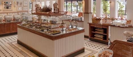 Un buffet proposant une variété de plats, un îlot central et un espace détente avec un sol à motifs.