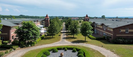 A residential area with brick buildings, a central pathway, and well-maintained gardens.