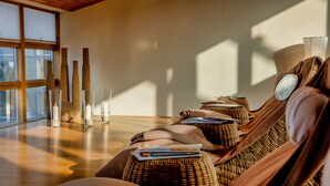 A room with wicker furniture, a large window, and a lamp. - Sunday Resort Rügen (Sagard)