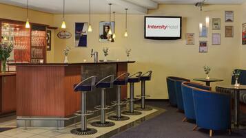 Eine Hotlellobby mit einer Rezeption, einer Bar und Sitzgelegenheiten.