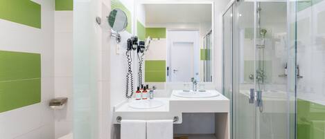 A modern bathroom with two sinks, a toilet, and a glass-enclosed shower.