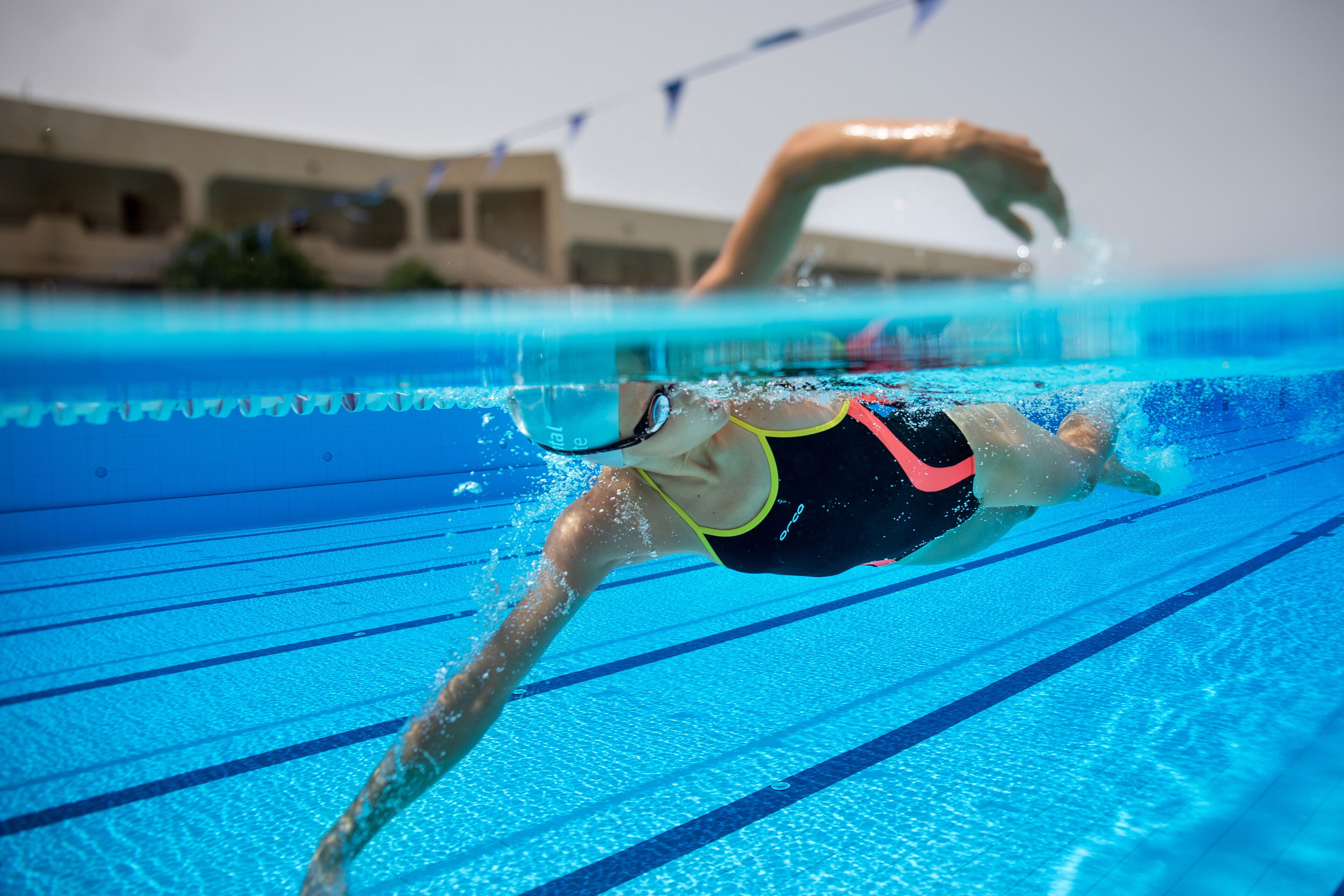 A swimmer in a pool with lane dividers.