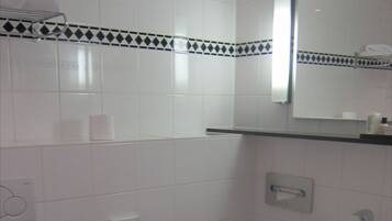Een badkamer met een toilet, een wastafel en een prullenbak.