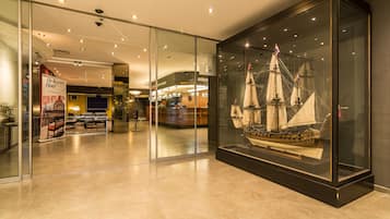 A modern hotel lobby with a glass display case containing a model ship.