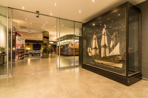 Un moderno vestíbulo de hotel con una vitrina de vidrio que contiene una maqueta de barco.
