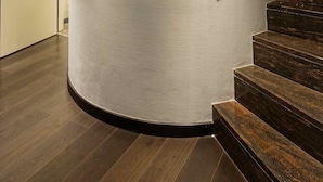 Un interior moderno con una pared curva, una escalera y una puerta.