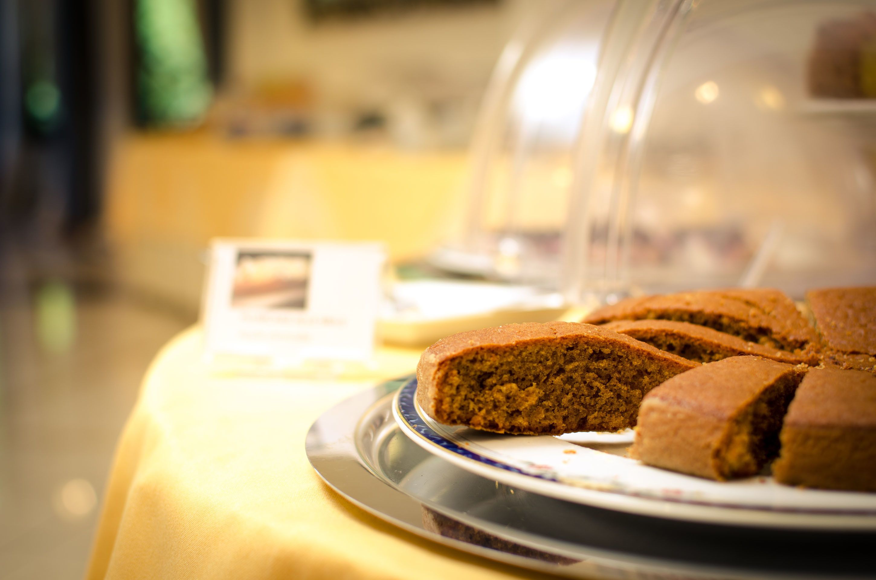 A display of gingerbread cookies under a glass dome on a table.