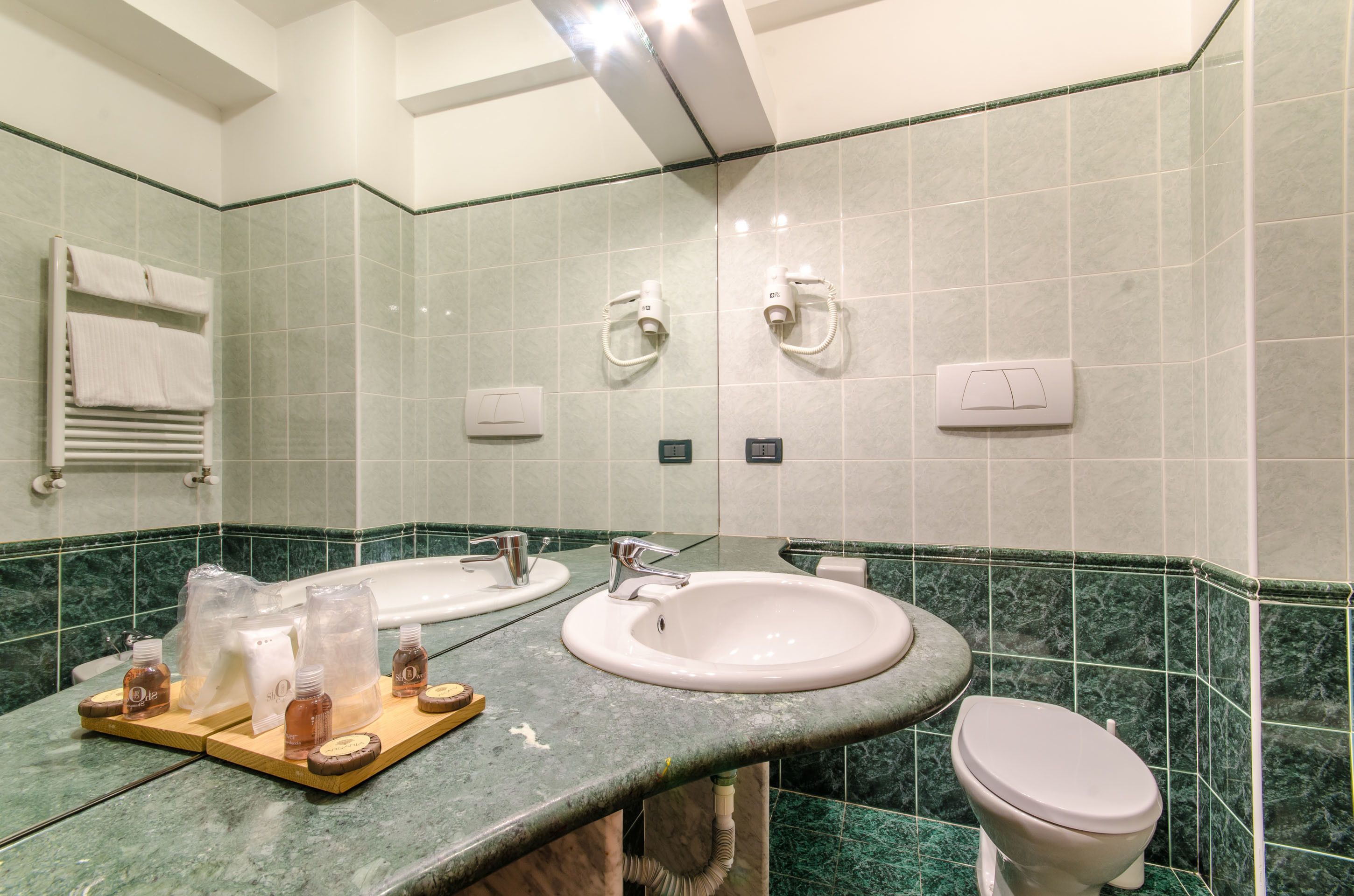 Une salle de bain avec deux lavabos, des toilettes et un porte-serviettes.