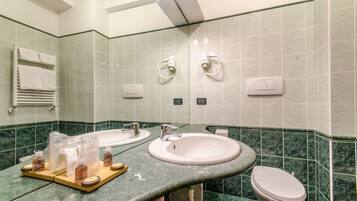 Une salle de bain avec deux lavabos, des toilettes et un porte-serviettes.
