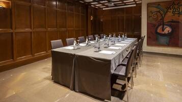 Ein Konferenzraum mit langem Tisch, vorbereitet für Meetings, ausgestattet mit Mikrofonen und Wasserflaschen.