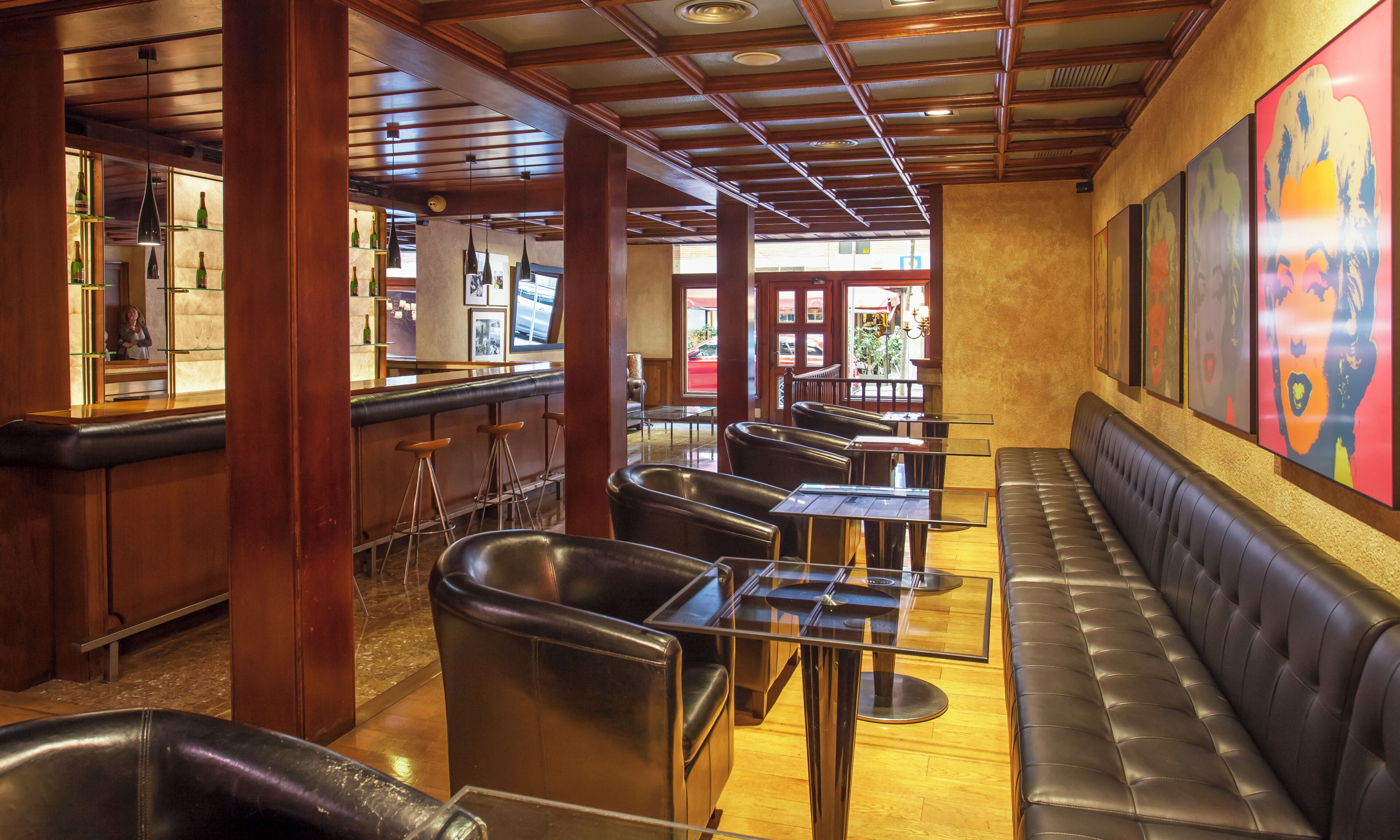 Ein Restaurantinnenraum mit Sitzecken, Stehtischen und einer Bar.