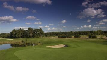 A golf course with a water hazard, sand bunkers, and a flagstick.