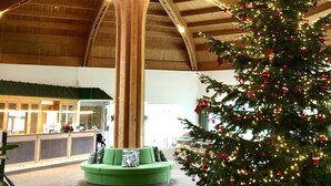 A spacious lobby with a large wooden ceiling and a decorated Christmas tree. - GolfResort Semlin (Rathenow)