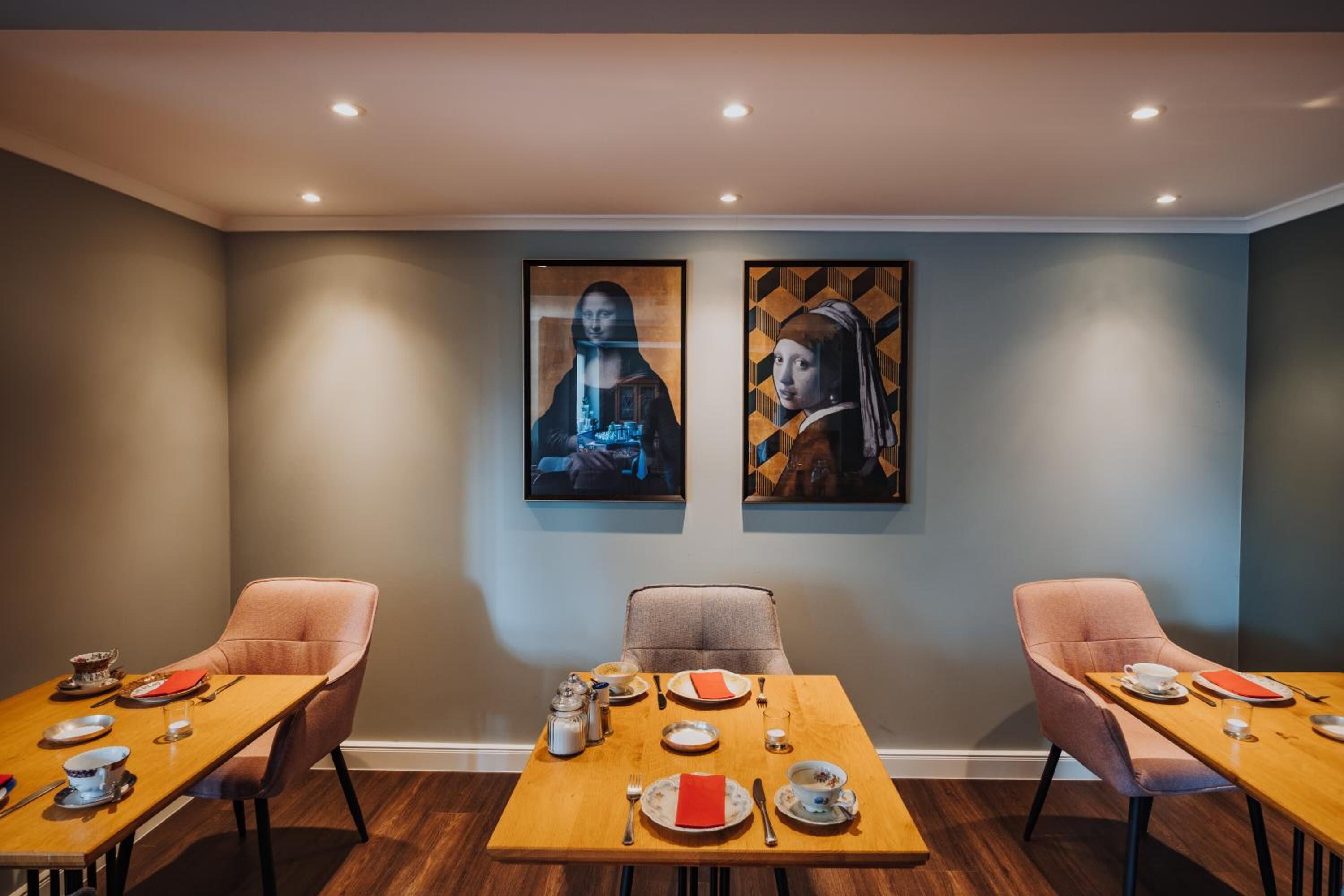 A dining area with two tables, each with chairs, set for a meal.