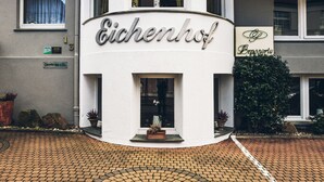 Um edifício com uma placa que diz 'Eichenhof' e 'Brasserie', indicando um restaurante ou estabelecimento para refeições.
