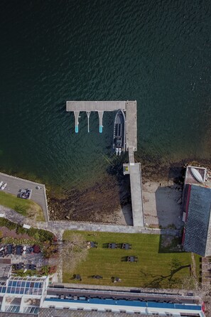 Waterfront property with a dock, lounge chairs, and a swimming pool.