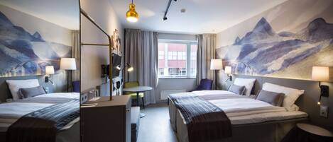 A hotel room with two beds, a desk, a chair, a small table, and a window with curtains.