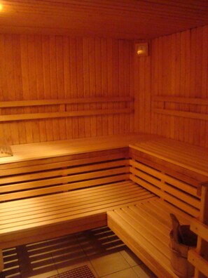 A sauna with wooden benches and a bench seat. - Golfhotel Fahrenbach (Trostau)