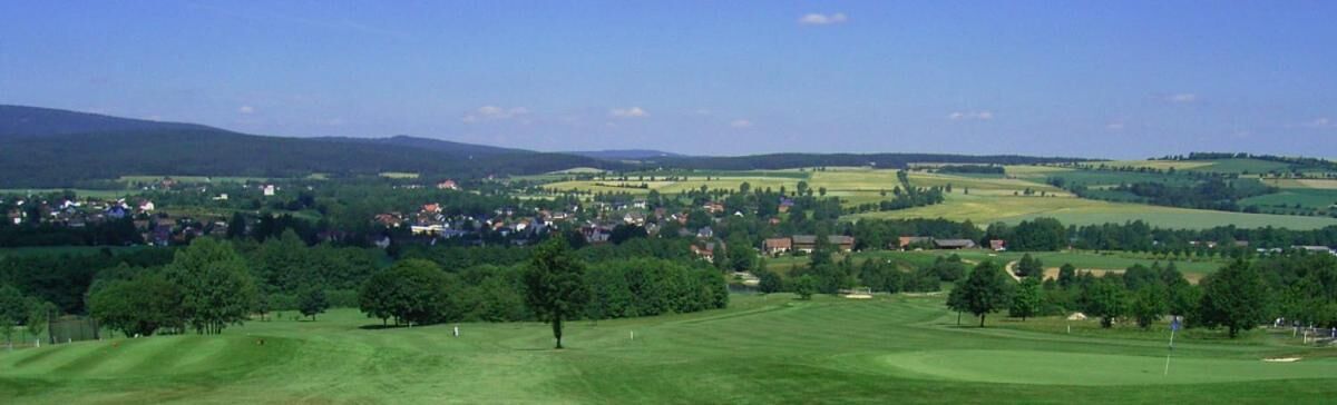 Un terrain de golf avec une ville en arrière-plan.