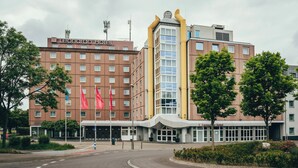 Un hotel con fachada moderna, varios pisos y una entrada destacada con marquesina.
