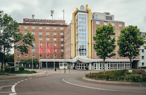 Un hotel con fachada moderna, varios pisos y una entrada destacada con marquesina.