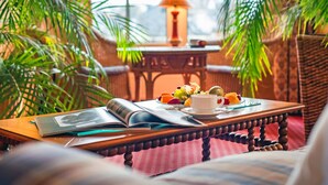 Un rincón acogedor para leer, con una mesa de madera, una lámpara y un cuenco de fruta.