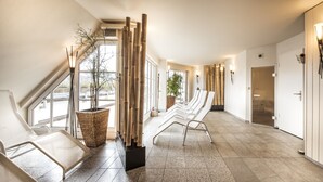 Un moderno vestíbulo de hotel con una larga recepción, zona de estar y grandes ventanales.
