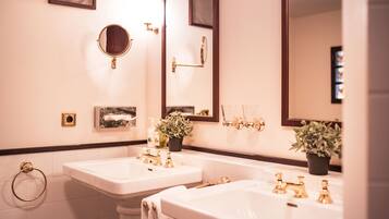 A bathroom with two sinks, a mirror, and a towel rack.