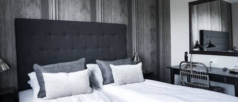 Una habitación de hotel moderna con una cama grande, un escritorio y una silla.