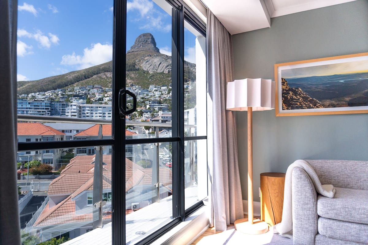 Ein Hotelzimmer mit großem Fenster und Blick auf Stadt und Berge.