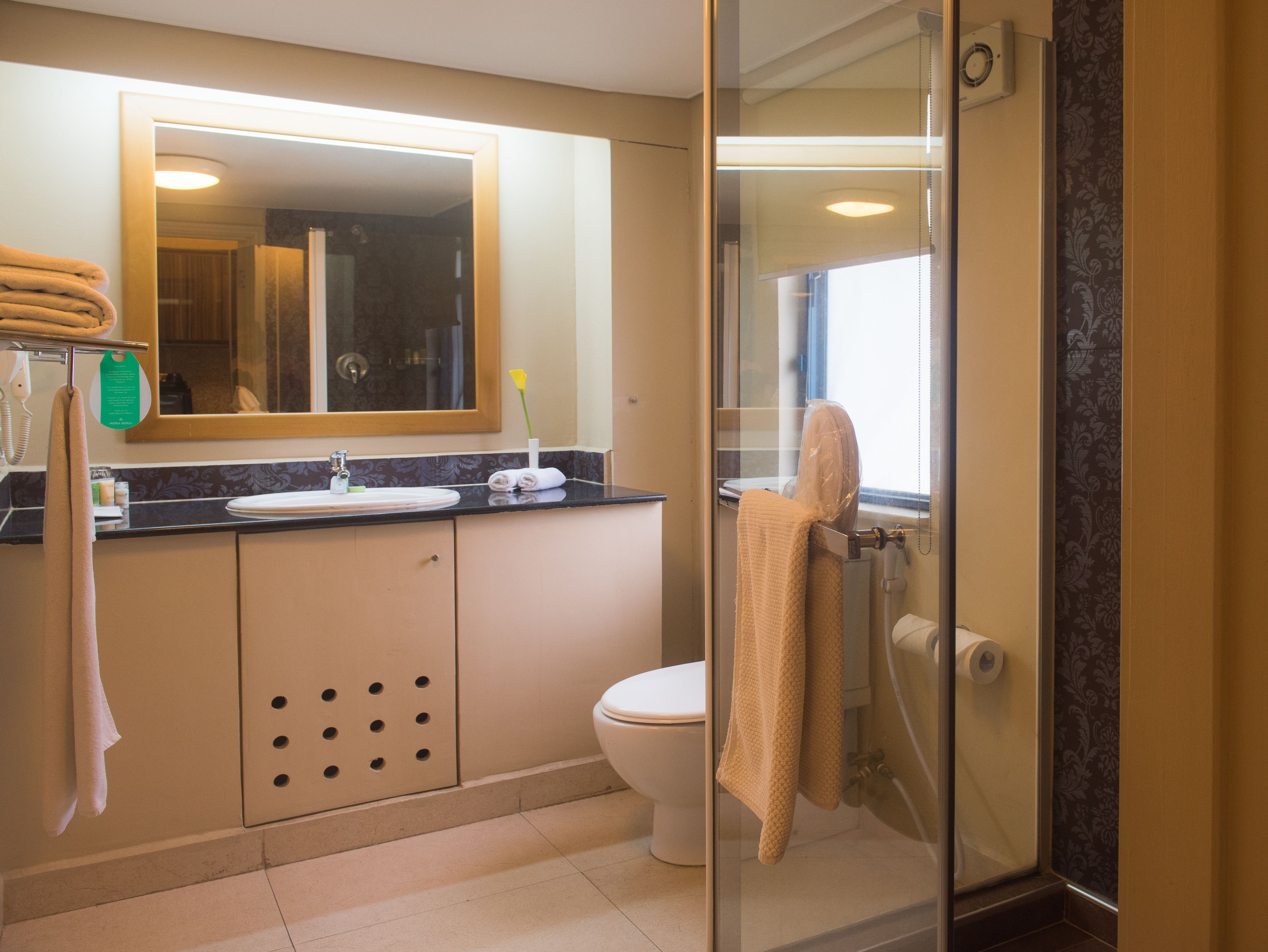 A bathroom with a toilet, sink, and shower area.
