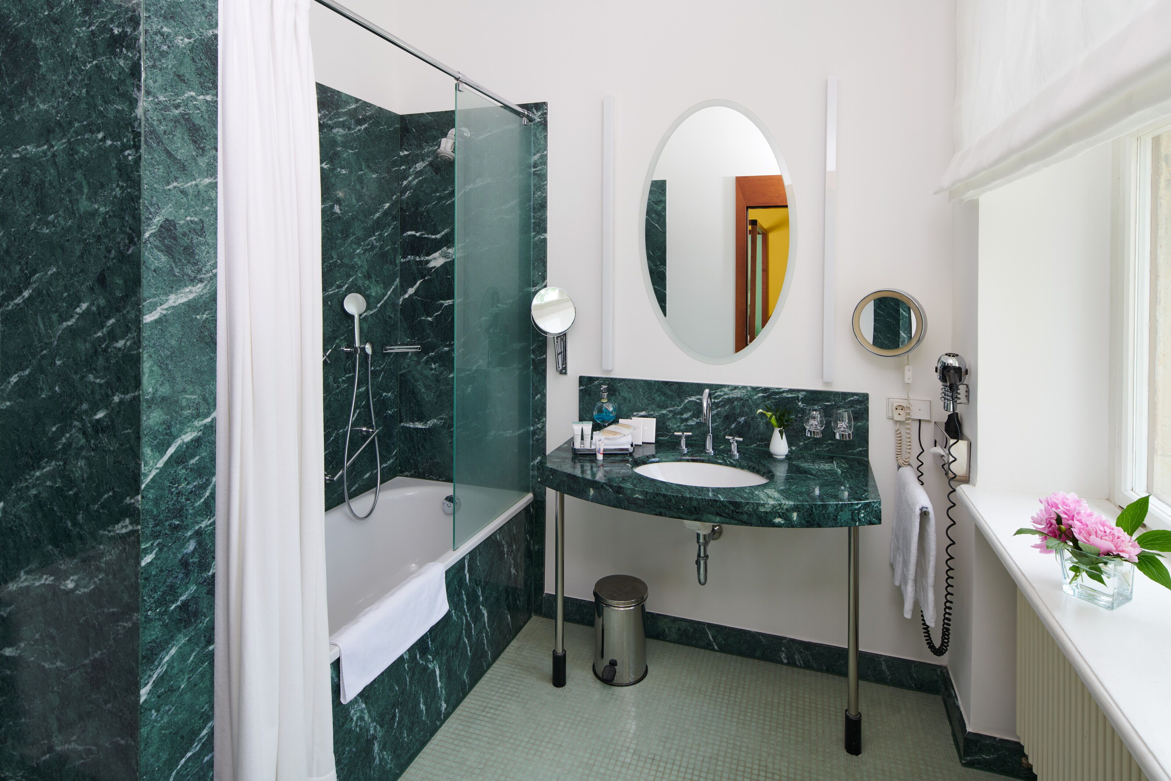 Ein Badezimmer mit Marmorwaschbecken, einer Badewanne und einer Duschkabine.