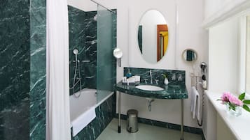 Ein Badezimmer mit Marmorwaschbecken, einer Badewanne und einer Duschkabine.