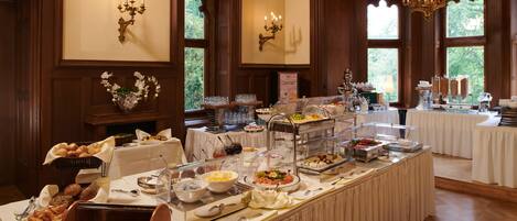 A buffet setup with various food items and a decorative vase.