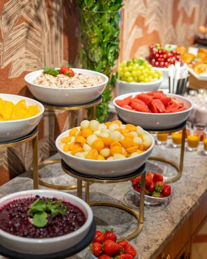 A buffet with various fruits and dishes. - The Alex (Dublin)