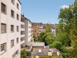 Residents enjoy a rooftop view of lush greenery and trees from their balconies.